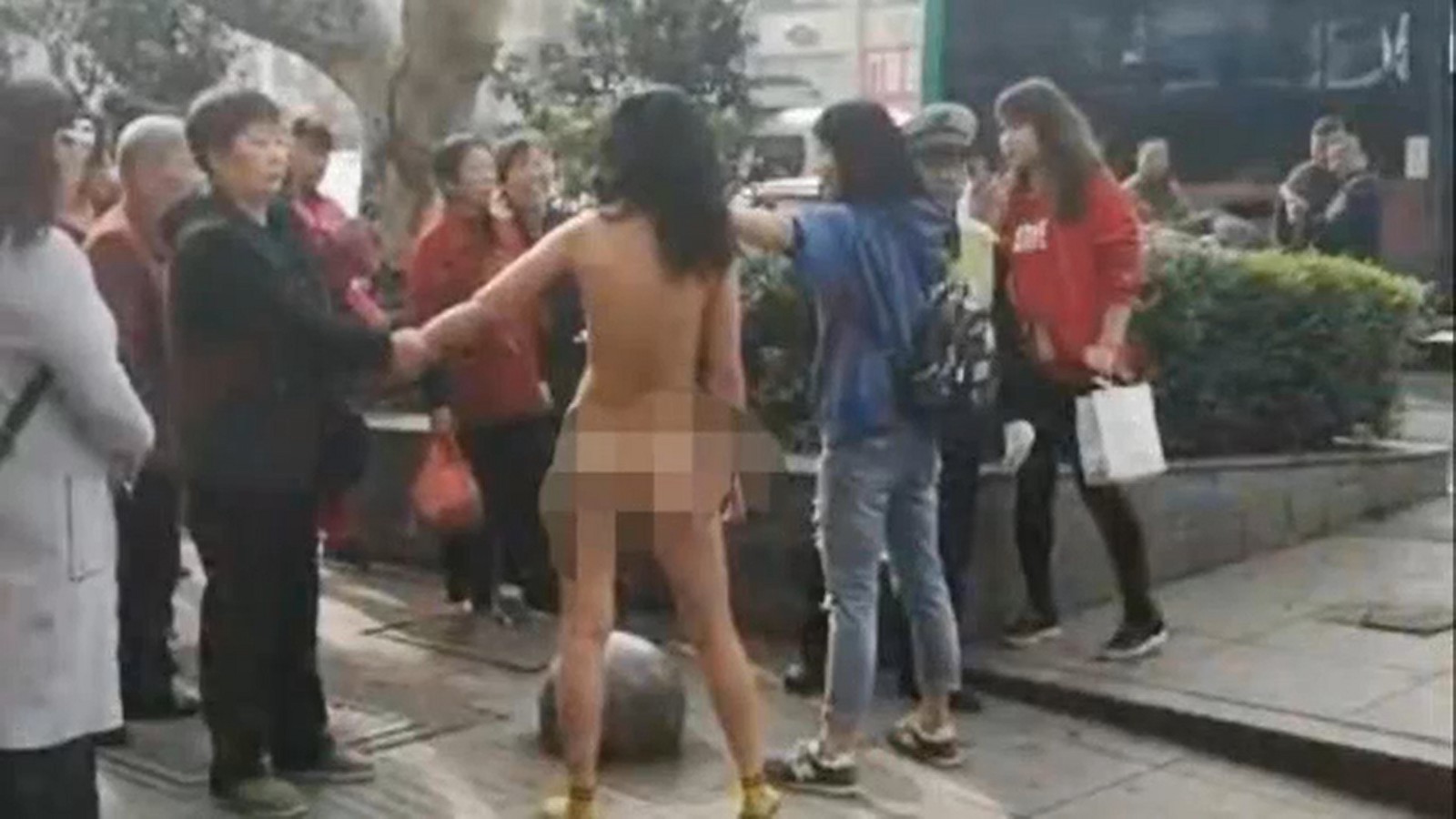 Young thief stripped naked in busy public street after